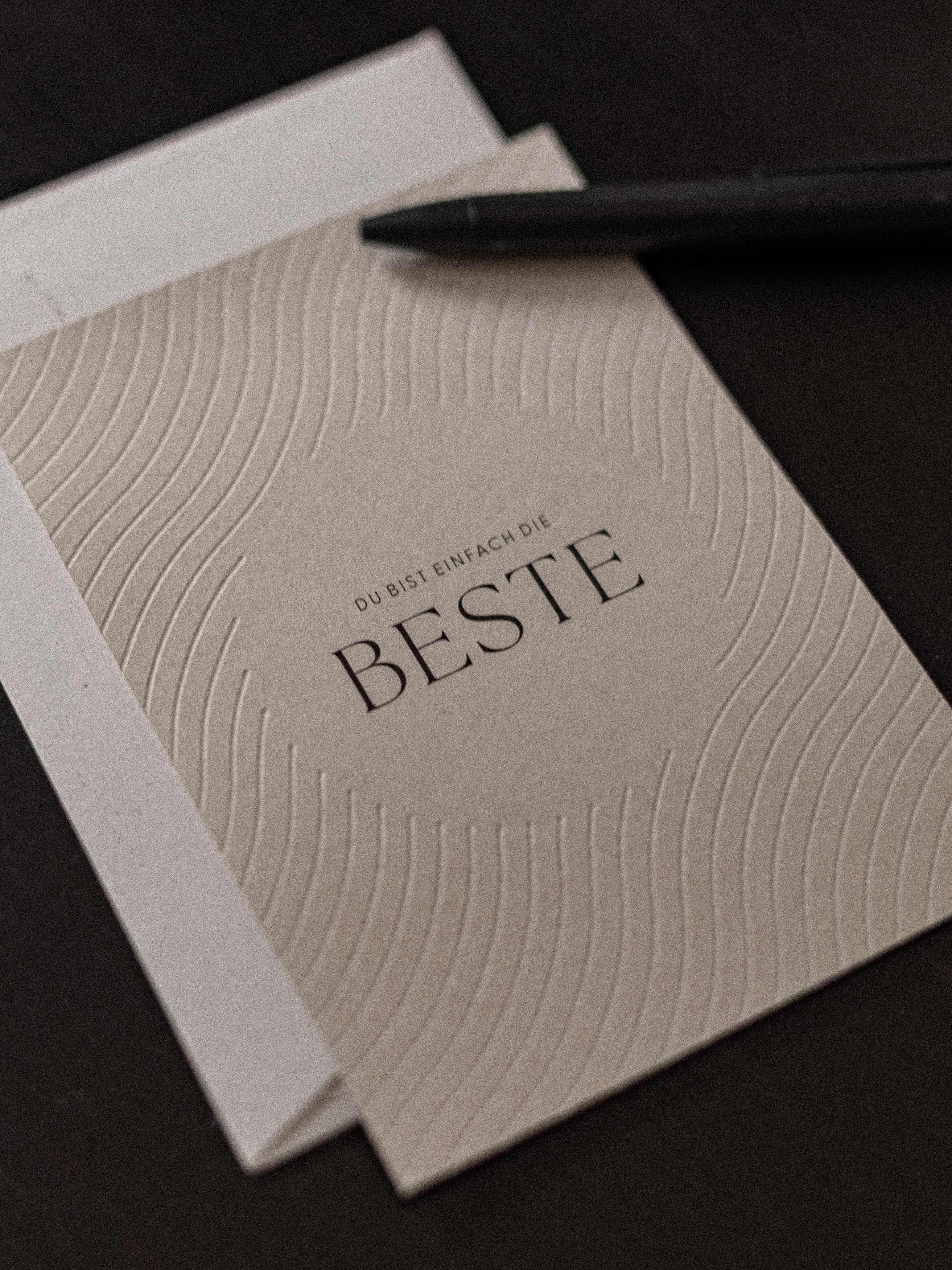 Karte liegt auf weissem Couvert mit dunklem Kugelschreiber | Studio Wiis