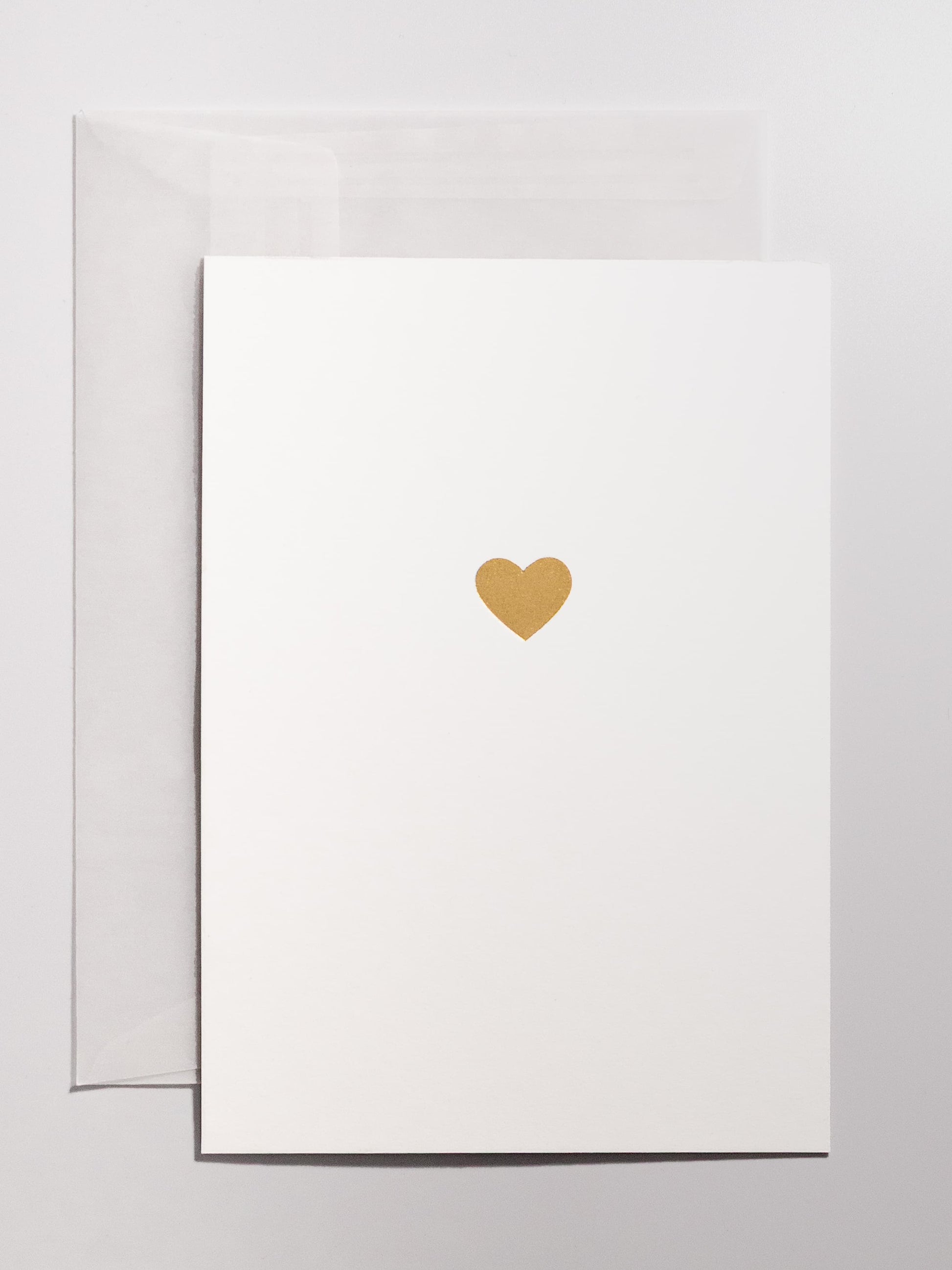 Weisse Grusskarte mit goldenem Herz im Hitnergrund mit transparentem Couvert in A6 | Studio Wiis
