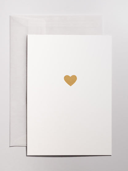 Weisse Grusskarte mit goldenem Herz im Hitnergrund mit transparentem Couvert in A6 | Studio Wiis