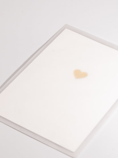 Schlichte weisse Karte mit goldem Herz in transparentem Couvert